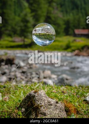 Sfera di vetro galleggiante, fiume nelle alpi austriache, Dorfer tal nel Parco Nazionale Hohe Tauern, giorno di sole in estate Foto Stock