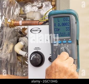 Analizzatore di gas di scarico su una caldaia esterna a gasolio per uso domestico durante la messa in funzione. Foto Stock