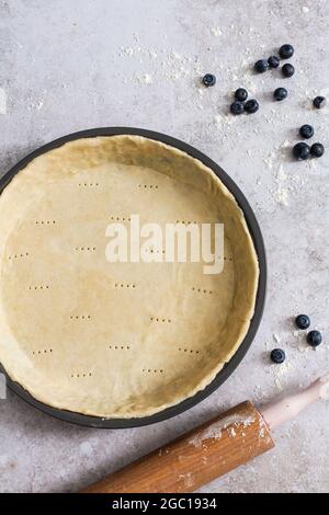 Pasta crostata cruda per torta di mirtillo nella preparazione. Foto Stock