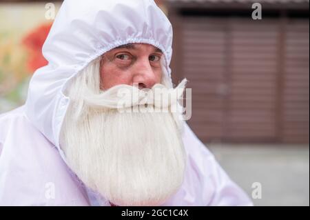 Ritratto di un uomo anziano con barba grigia e baffi in tuta protettiva. Foto Stock