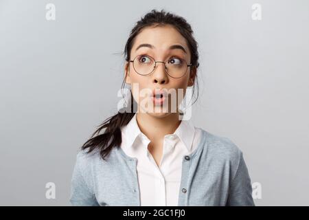 Pubblicità, persone e concetto di emozione. Ritratto di primo piano di impressionato e meravigliato ragazza asiatica vedere qualcosa di fantastico, fischio stupito, guardare Foto Stock