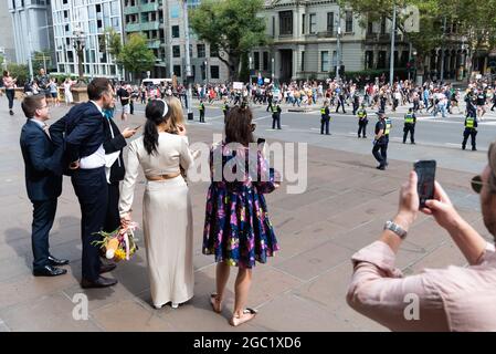 Gli sposi novelli si guardano durante la dimostrazione di Melbourne World-wide per la libertà ai Flagstaff Gardens di Melbourne, Australia, il 20 marzo 2021. In oltre 40 paesi di tutto il mondo si stanno celebrando dimostrazioni per rivendicare i diritti fondamentali e prendere posizione contro le eccessive restrizioni COVID-19. Credit: Mikko Robles/Speed Media/Alamy Live News Foto Stock