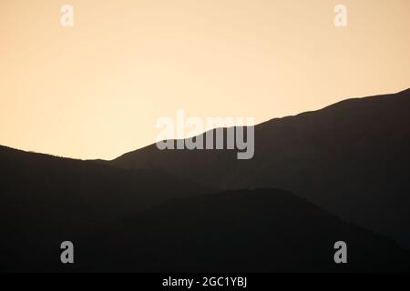 Silhouette di montagne sullo sfondo del tramonto. Foto Stock