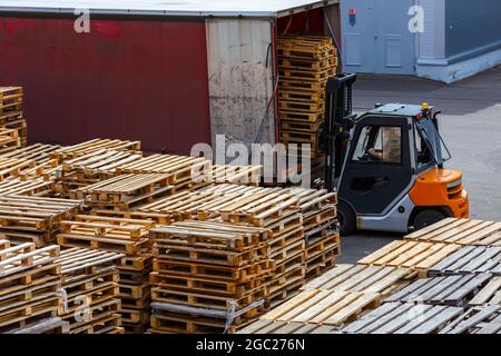 carrello elevatore a forche che carica pile di pallet in legno usate nel carrello - vista prospettica dall'alto Foto Stock