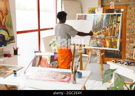 Pittore maschile afroamericano al lavoro in studio d'arte Foto Stock