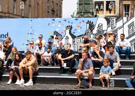 Edimburgo, Scozia, Regno Unito. 6 agosto 2021. Immagini dal Royal Mile nella città vecchia di Edimburgo il giorno di apertura del Festival della frangia di Edimburgo 2021. Il festival sembra molto diverso da due anni fa . Sono consentiti pochissimi spazi per spettacoli di strada e sono evidenti meno turisti. Anche un'elevata visibilità della polizia, ci sono più agenti di polizia che artisti per strada, è in netto contrasto con gli anni precedenti. PIC; l'audience guarda l'esecutore nello spazio delle performance della Cattedrale di St Gile. Iain Masterton/Alamy Notizie dal vivo. Foto Stock
