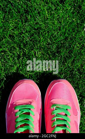 scarpe sportive rosa su fondo verde erba Foto Stock