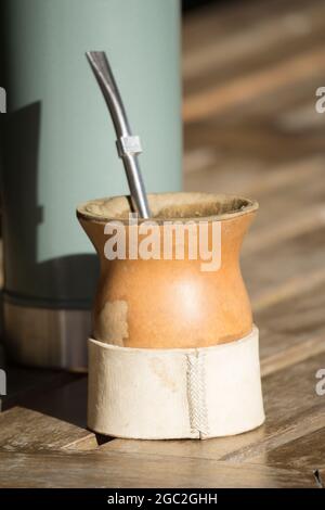 Closeup verticale di una tazza di infuso di yerba mate con un thermos. Foto Stock