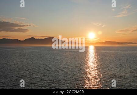 Alaska, Inside Passage, Costa del Pacifico; il sole sorge sulle montagne dell'isola di Baranof lungo la costa occidentale dell'Alaska sul passaggio interno. Foto Stock