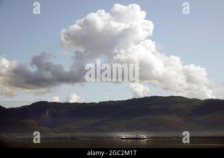 Alaska, Inside Passage, Pacific Coast; mentre una nave da crociera si muove lentamente a nord, la nebbia sale da Baranof Island nella mattina presto lungo la costa occidentale dell'Alaska sul passaggio interno. Foto Stock