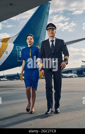 L'equipaggio di cabina in splendide uniformi che cammina avanti Foto Stock