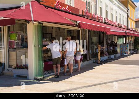 Porec, Croazia - 10 luglio 2021. I turisti decidono tra i diversi sapori del gelato sul lungomare della cittadina costiera medievale di Porec, Istria Foto Stock