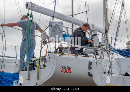 settimana dei cowes, manutenzione degli yacht, equipaggi di yacht, cowes yacht haven, isola di wight, equipaggio che lavora su yacht da corsa, regata di vela, regata di yacht. Foto Stock