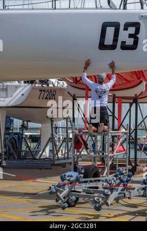 settimana dei cowes, manutenzione degli yacht, equipaggi di yacht, cowes yacht haven, isola di wight, equipaggio che lavora su yacht da corsa, regata di vela, regata di yacht. Foto Stock