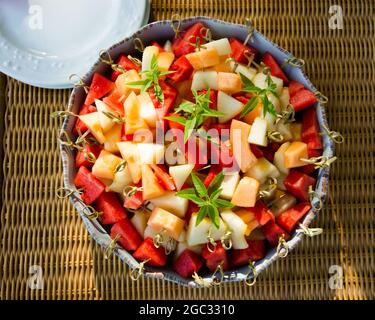Grande piatto di frutta fresca tagliata, melone, cocomero, su bastoncini di bambù. Foto Stock