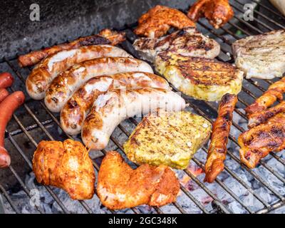 Bratwurst e bistecca sulla griglia al carbone Foto Stock