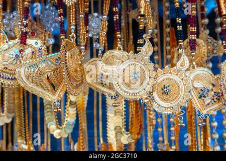 I pezzi di collo placcati oro auspicious sono appesi per la vendita alle donne del Bengala indiano, a Kalighat, Kolkata, Bengala occidentale, India. In Hinduism, simboliz oro Foto Stock