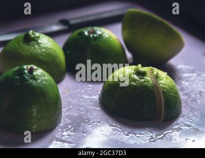 Lime dimezzate su un tagliere Foto Stock