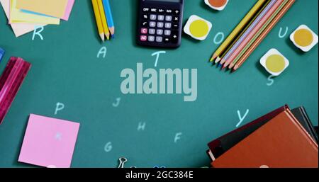 Composizione digitale di alfabeti multipli che galleggiano contro le attrezzature stazionarie della scuola sul surf verde Foto Stock