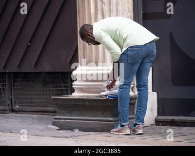 Man che esegue l'autotest dell'antigene rapido del covid-19, noto anche come Rapid Lateral Flow Test, per verificare il test del covidio del coronavirus Covid-19 in London Street Foto Stock