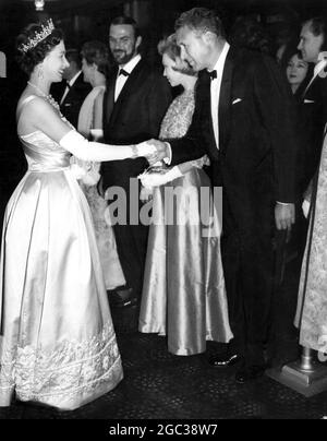 Sua Maestà la Regina Elisabetta II in prima cinematografica scuote le mani con Anthony Quayle una delle stelle del film The Guns of Navarone 27 aprile 1961 Foto Stock
