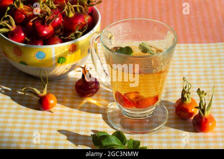 Tè alle rose e frutti di rosa selvatici in una ciotola. Primo piano. Foto Stock