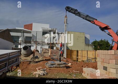 Muratore. Muratori in cantiere con scala che lavora su costruzioni per il posizionamento di travi in calcestruzzo prestampate per pareti in calcestruzzo Foto Stock
