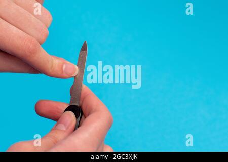 La cura del corpo delle mani. Donna lucidare le unghie con la lima per unghie. Foto Stock