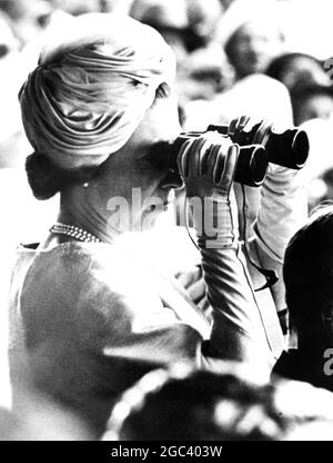 LA REGINA IN NUOVA ZELANDA LA REGINA guarda attraverso il binocolo alla corsa della regina Elisabetta II handicap al Riccanton Racecourse, Christchurch. 16 febbraio 1963 Foto Stock