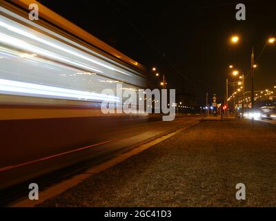 il movimento del tram sfocato passa di notte, esposizione lunga Foto Stock