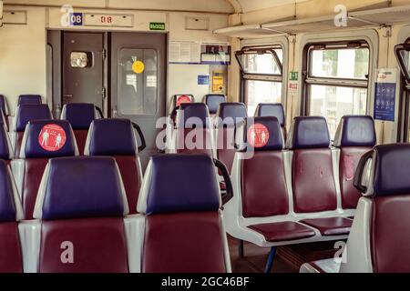 MOSCA, RUSSIA - GIUGNO, 12, 2021: Sedie in treno con adesivi sulla distanza sociale di sicurezza 1,5 m e indossare maschere e guanti a Mosca, Russia Foto Stock