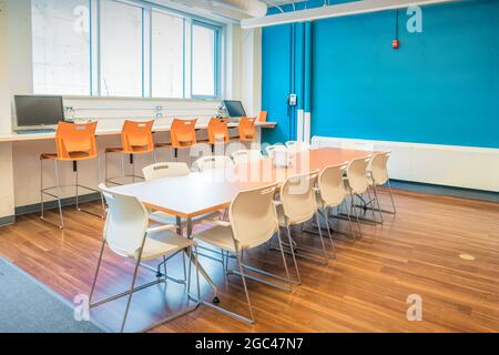 Cucina d'ufficio e sala da pranzo con grande tavolo e sedie Foto Stock