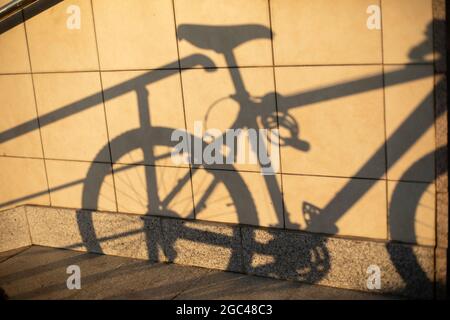 L'ombra della bicicletta sulla parete. Silhouette di trasporto meccanico su una piastrella. L'immagine di una bici sportiva. Foto Stock