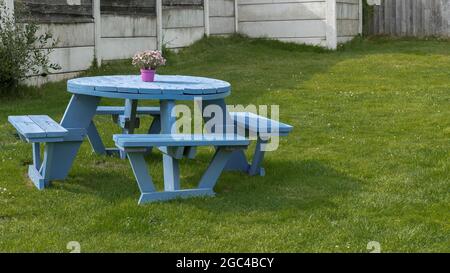 Tavolo dipinto di blu in un giardino Foto Stock