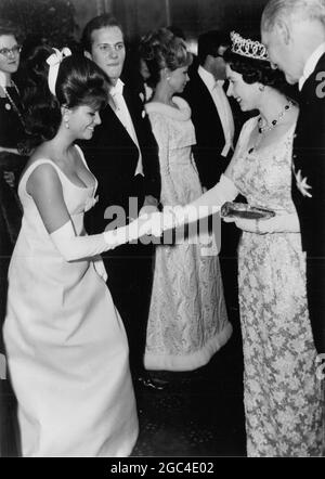 Claudia Cardinale viene presentata a sua Maestà la Regina sul palco del Leicester Square Odeon prima della proiezione della West Side Story . Pat Boone (centro a sinistra) e l'attrice francese Dany Robin (centro a destra). 26 febbraio 1962 Foto Stock