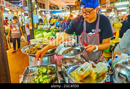 LAMPANG, THAILANDIA - 8 MAGGIO 2019: Il venditore cuoce il pesce al vapore con verdure nel mercato di Ratsada, l'8 maggio a Lampang Foto Stock