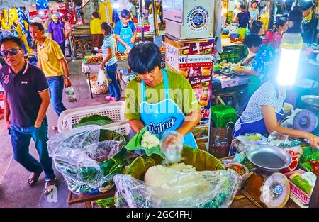 LAMPANG, THAILANDIA - 8 MAGGIO 2019: I venditori alimentari nel mercato occupato Ratsada offre riso pronto, avvolto in foglia di banana, l'8 maggio a Lampang Foto Stock