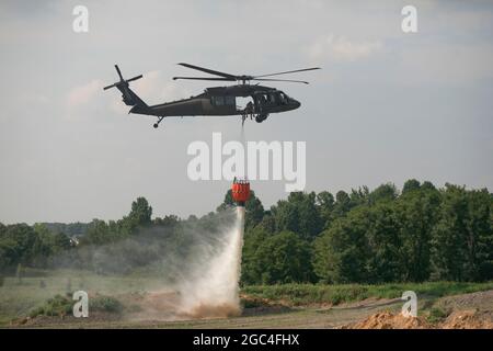 I soldati della Guardia Nazionale dell'Esercito del Kentucky cadono acqua mentre conducono l'addestramento del secchio dell'acqua al centro regionale di addestramento di H. Ford di Wendhell a Greenville, KY il 19 luglio 2021. I membri dell'equipaggio della Bravo Co., 2/147th Assault Helicopter battaglione treni utilizzando UH-60 Black Hawks per estinguere incendi boschivi e incendi selvaggi per assistere i vigili del fuoco locali in tutto il Kentucky e negli stati vicini. Questa immagine è stata ritagliata elettronicamente e migliorata eticamente per enfatizzare il soggetto e non travisare il soggetto o l'immagine originale in alcun modo (U.S.A. Esercito foto di staff Sgt. Andrew Dickson). Foto Stock