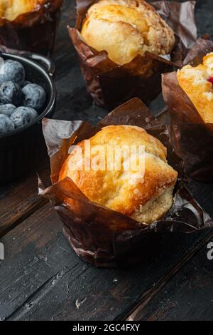 Muffin al mirtillo con berrie fresca, su vecchio sfondo di legno scuro tavolo Foto Stock