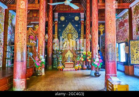 LAMPANG, THAILANDIA - 8 MAGGIO 2019: L'interno scenico dell'Ubosot di Wat Pratu Pong, decorato con statua dorata di Buddha e motivi fini, l'8 maggio Foto Stock