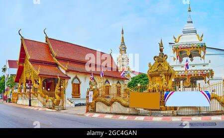 Panorama del tempio Wat si Bunruang con il campanile bianco ho Rakang, chedi ornati e la sala Viharn, Lamphun, Thailandia Foto Stock