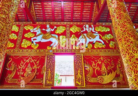 LAMPANG, THAILANDIA - 8 MAGGIO 2019: Le splendide decorazioni interne nel viharn Wat Phrao di Wat Phra che Lampang Luang con motivi dorati in rilievo, parete Foto Stock