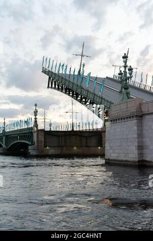 Trinità ponte sul fiume Neva con la sua parte sollevata è a metà strada fino alla posizione regolare, alle 3:53 am, San Pietroburgo, Russia Foto Stock