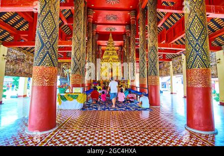 LAMPANG, THAILANDIA - 8 MAGGIO 2019: Lo scenografico Viharn Luang interno di Wat Phra che Lampang Luang con colonne di teak, coperto con motivi fini e Ku Foto Stock