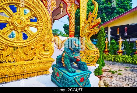 La scultura dorata della ruota del Dharma, piccolo Leone Imperiale Guardiano Cinese, chiamato anche Foo Dog e serpente Naga, situato di fronte a Wat Thong Foto Stock