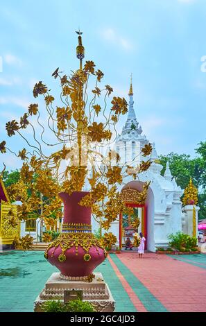 Il bouquet di lotus d'oro in bellissimo vaso è elemento decorativo, situato di fronte a Viharn Luang di Wat Phra che Hariphunchai Tempio, Lamphun, Foto Stock