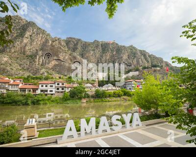 AMASYA, TURCHIA, 14 2021 GIUGNO; Città di Amasya. Vecchie case vicino al fiume e Amasya segno. Foto Stock