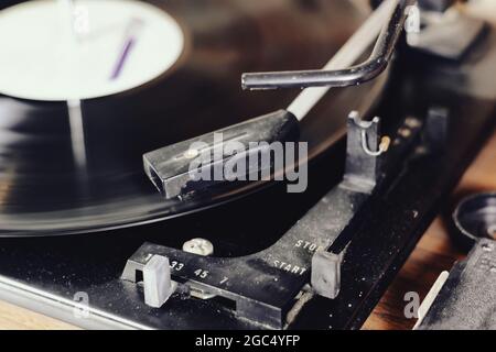 l'ago di un giradischi che riproduce le tracce di un disco in vinile nero. Impianto audio vintage. Lettore di dischi in vinile Foto Stock