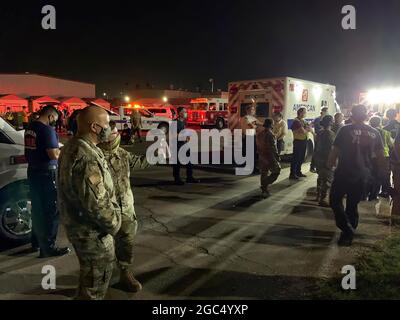 I guardiani nazionali della California, il dipartimento dei vigili del fuoco di Fresno e i servizi medici di emergenza della contea di Fresno attendono l'arrivo di un elicottero CH-47 Chinook della Brigata dell'aviazione di combattimento che trasporta gli evacuati dal fuoco del torrente alla linea di volo del 1106 del gruppo di manutenzione dell'aviazione del supporto del teatro a Fresno, California, 6 settembre 2020. Il Dipartimento militare della California ha evacuato oltre 200 persone lungo il bacino idrico di Mammoth Pool quando l'incendio del Creek è esploso in dimensioni. (STATI UNITI Air National Guard foto di Capt. Jason Sanchez) Foto Stock