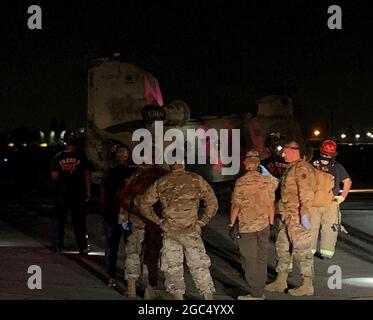 I guardiani nazionali della California, il dipartimento dei vigili del fuoco di Fresno e i servizi medici di emergenza della contea di Fresno attendono di dirigere gli evacuatori di un elicottero CH-47 Chinook della Brigata dell'aviazione di combattimento 40 dal fuoco del torrente alla linea di volo del 1106 del gruppo di manutenzione dell'aviazione di supporto a Fresno, California, 6 settembre 2020. Il Dipartimento militare della California ha evacuato oltre 200 persone lungo il bacino idrico di Mammoth Pool quando l'incendio del Creek è esploso in dimensioni. (STATI UNITI Air National Guard foto di Capt. Jason Sanchez) Foto Stock